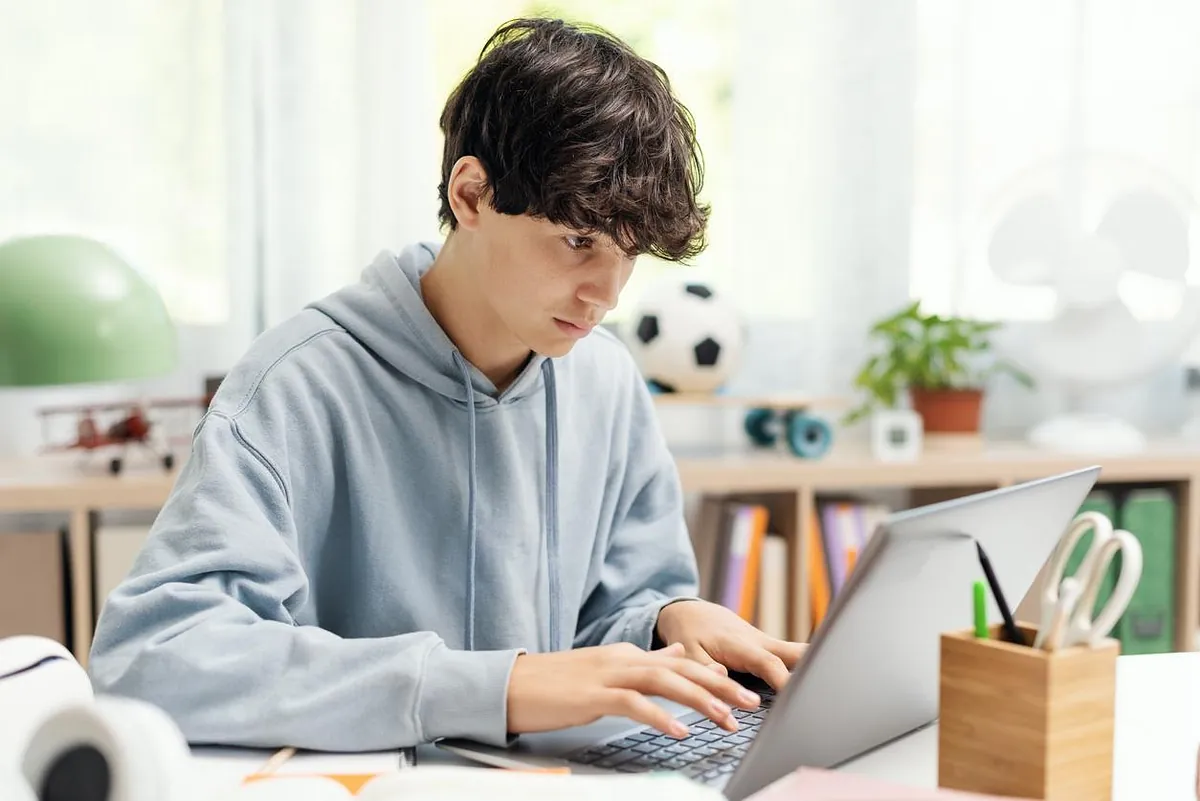 Ung gutt jobber på laptop